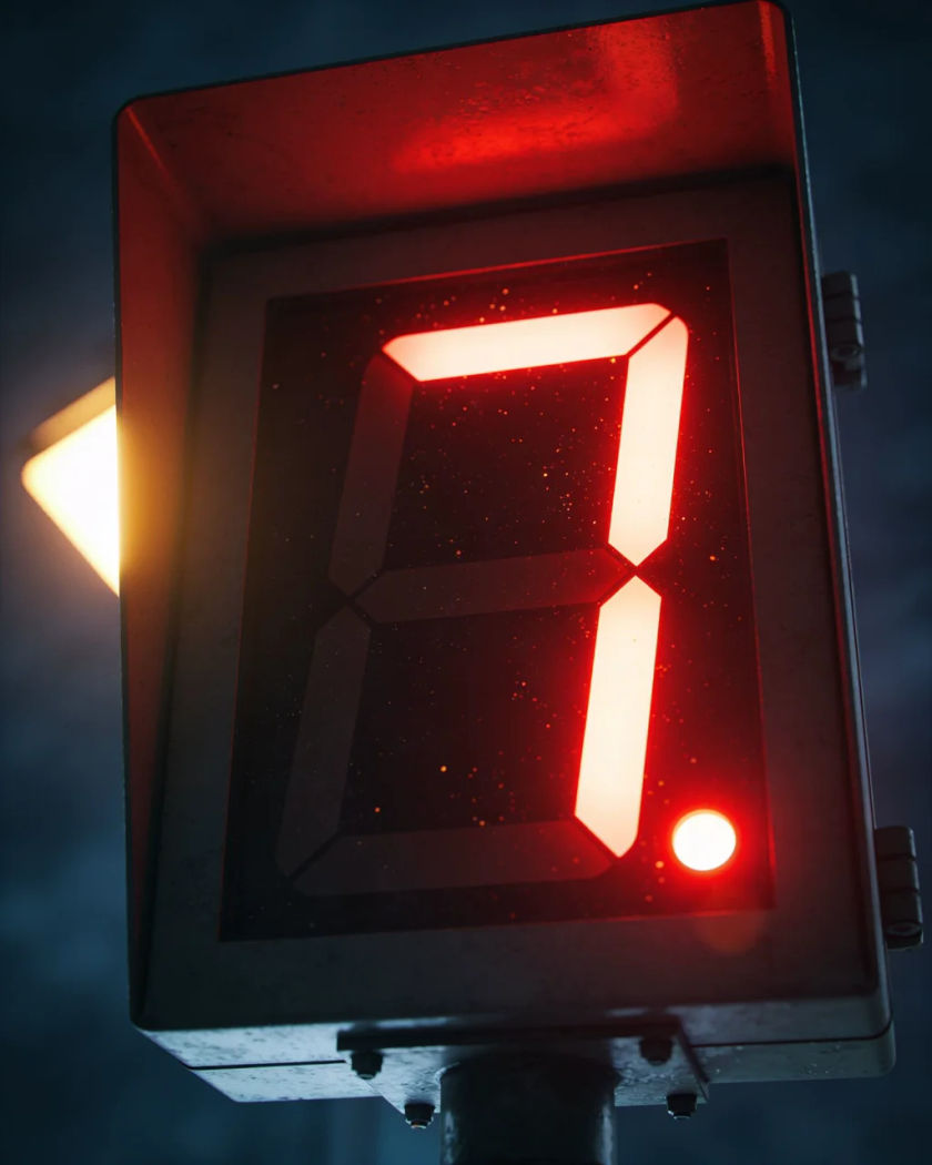 A glowing red digital timer display in warm light against a cold dark ground, a final segment lit as the count reaches zero