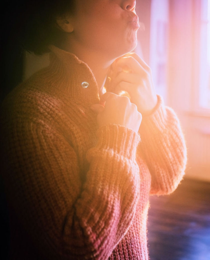 A soft-lit close frame of a mouth and cheeks caught mid-sigh, warm colour filling the whole image