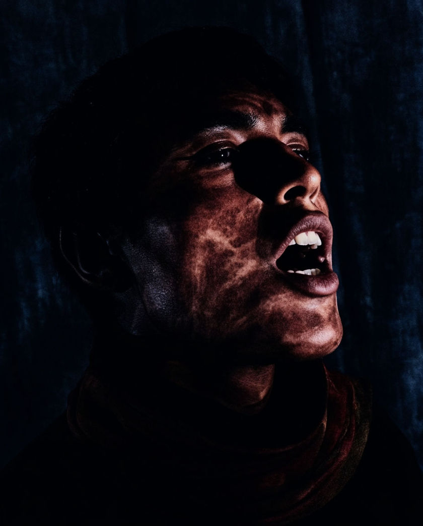 A mouth caught open mid-breath in raking side light, the rest of the face falling into shadow