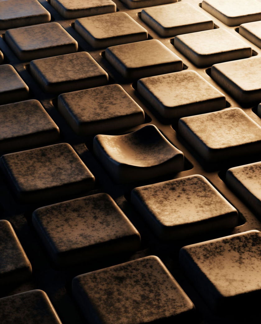 A worn keypad filling the frame at a low angle, one key pressed and catching a hard edge of light