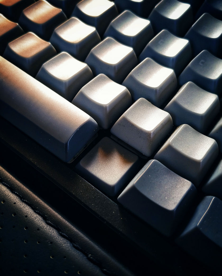 A mouse button caught at the moment of depression in raking light, everything else dark