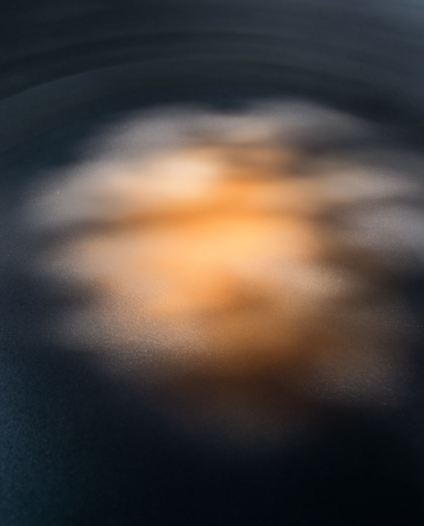 A phone face down on a dark desk with the edge glow of a notification spilling out around it