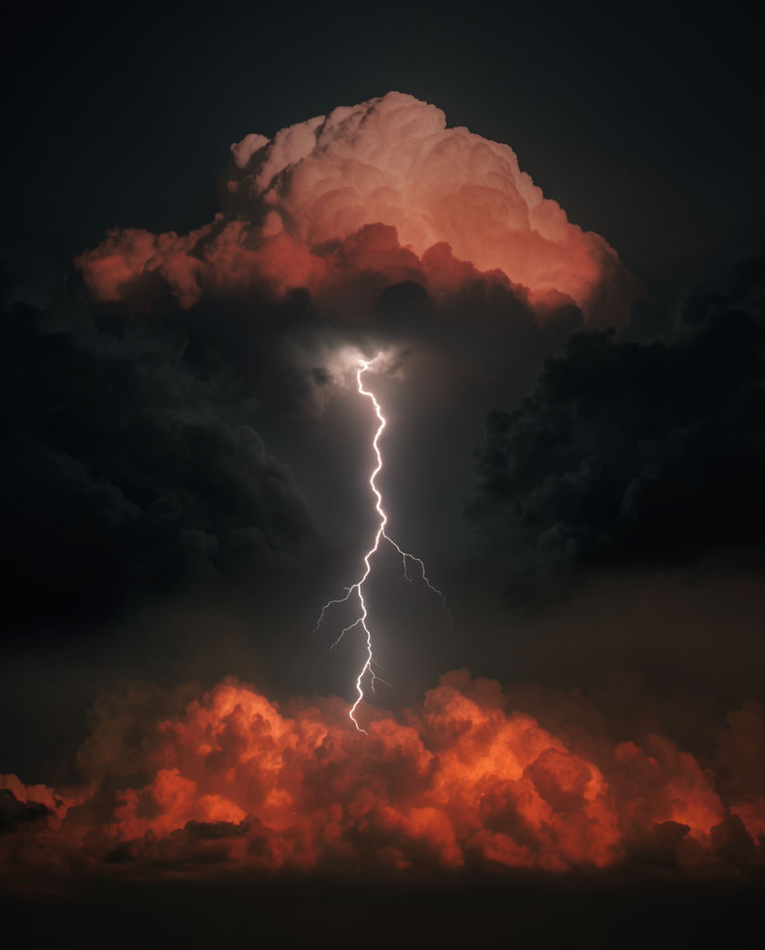 A single fork of lightning splitting a black sky over a dark ridge, cloud lit from within