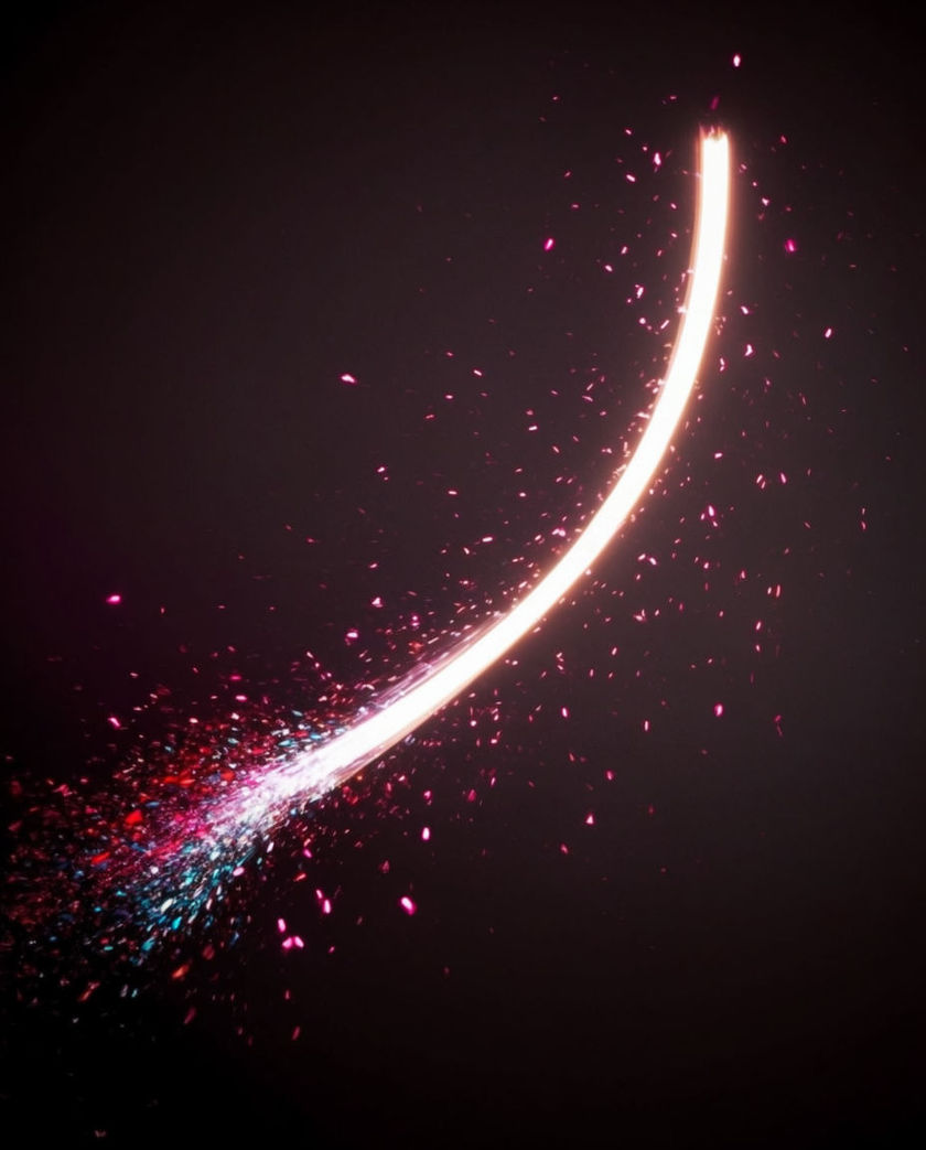A snare drum lit from one side with a mallet blurred mid-roll, warm skin against a dark cool ground