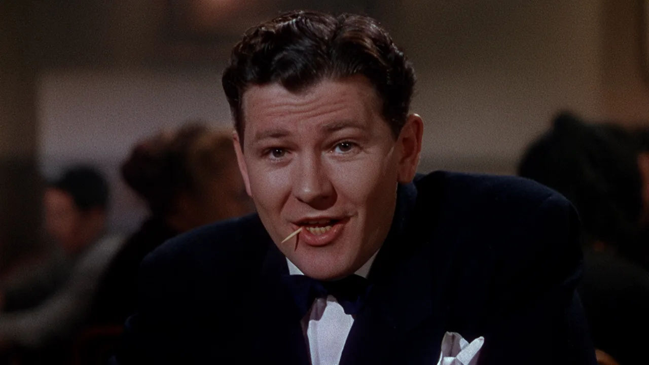 Studio-era character speaking to camera under warm key light