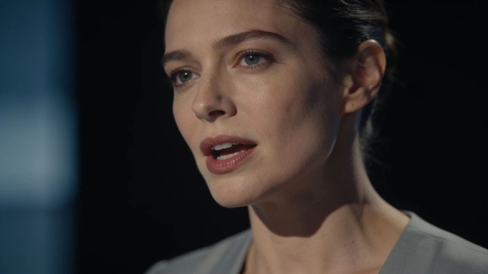 Poised broadcast presenter speaking in cinematic portrait