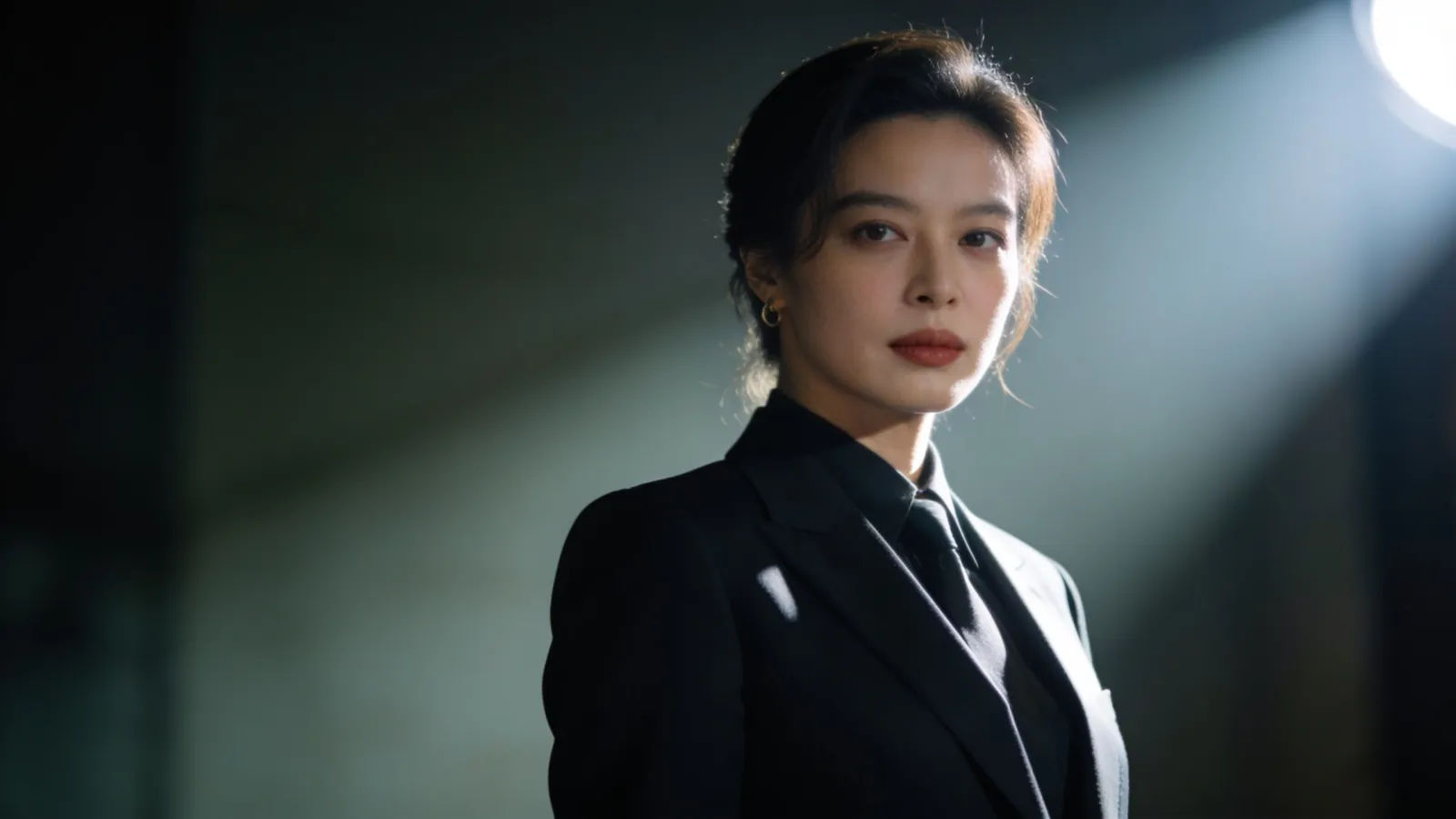 Confident composed figure with commanding gaze, bold light