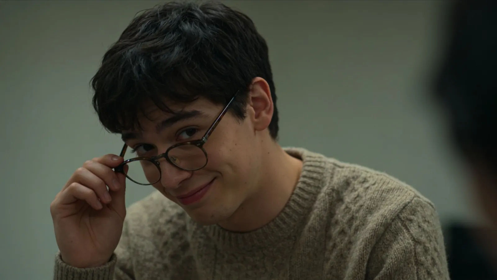 Nervous self-conscious young man mid-fidget, sheepish smile
