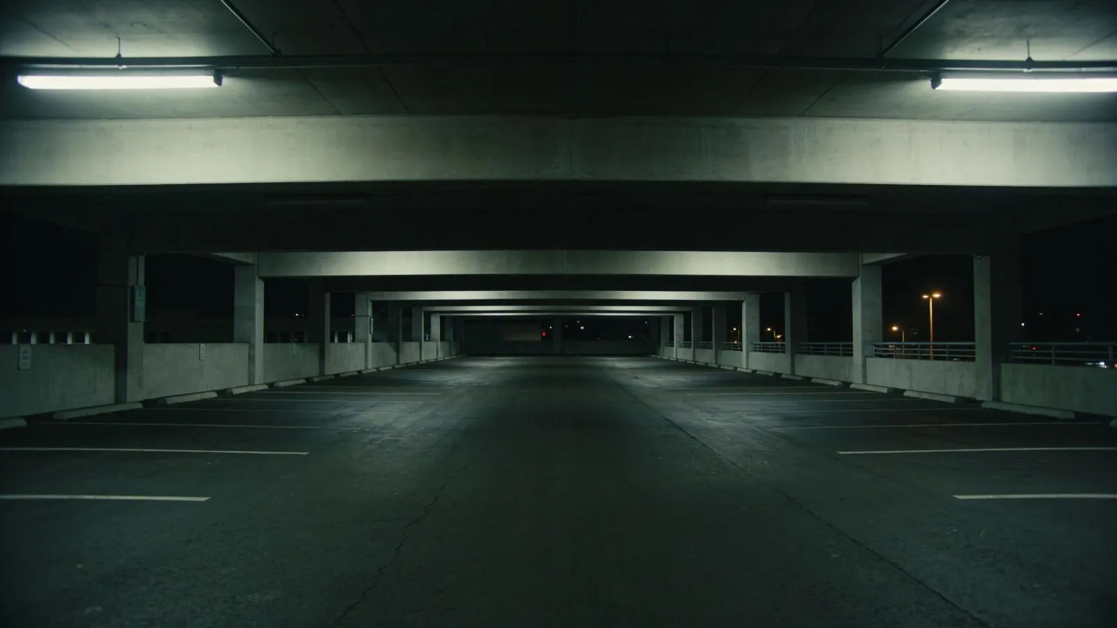 Dim night parking structure, long empty perspective