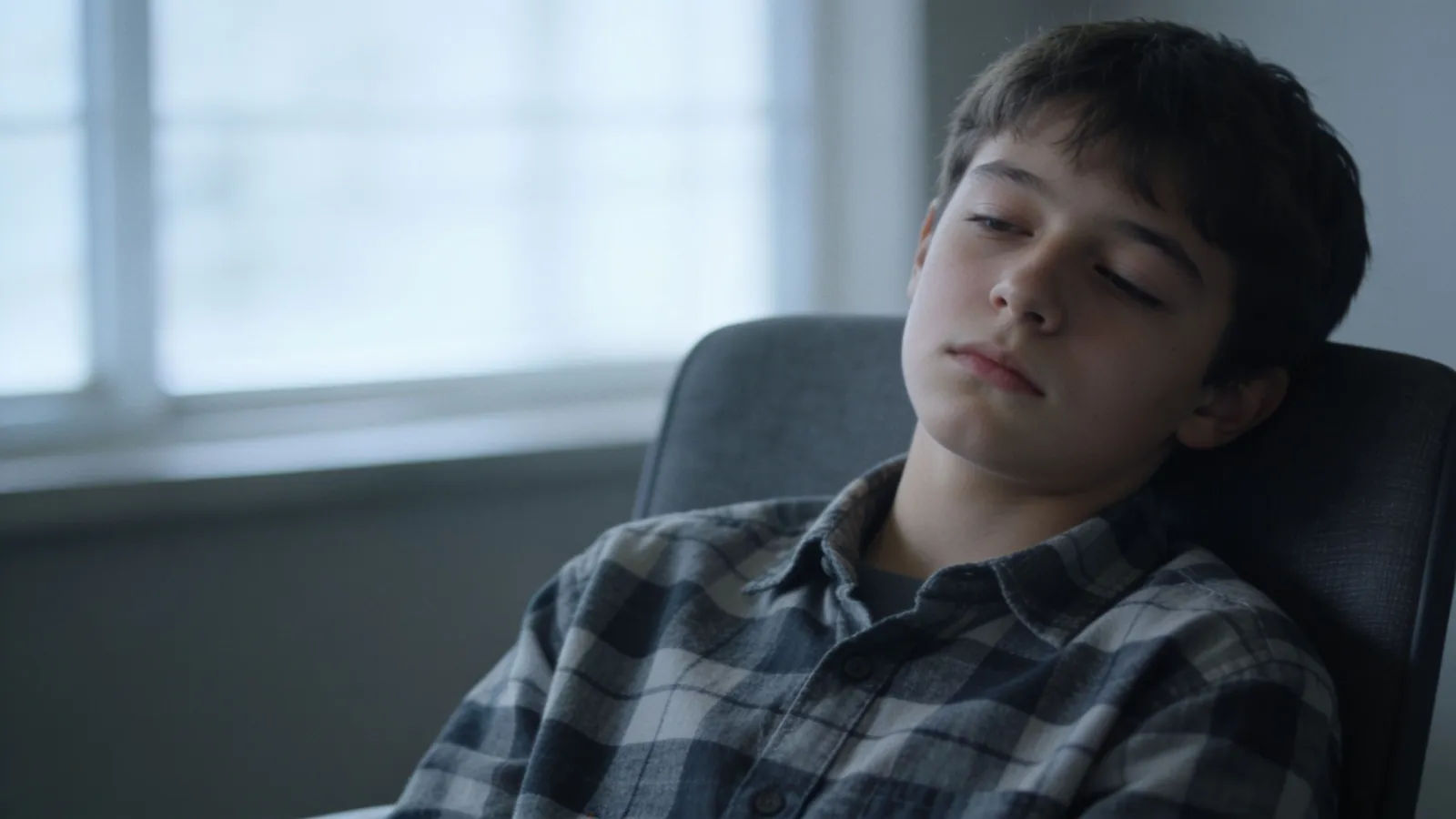 Checked-out teenager with a flat deadpan expression