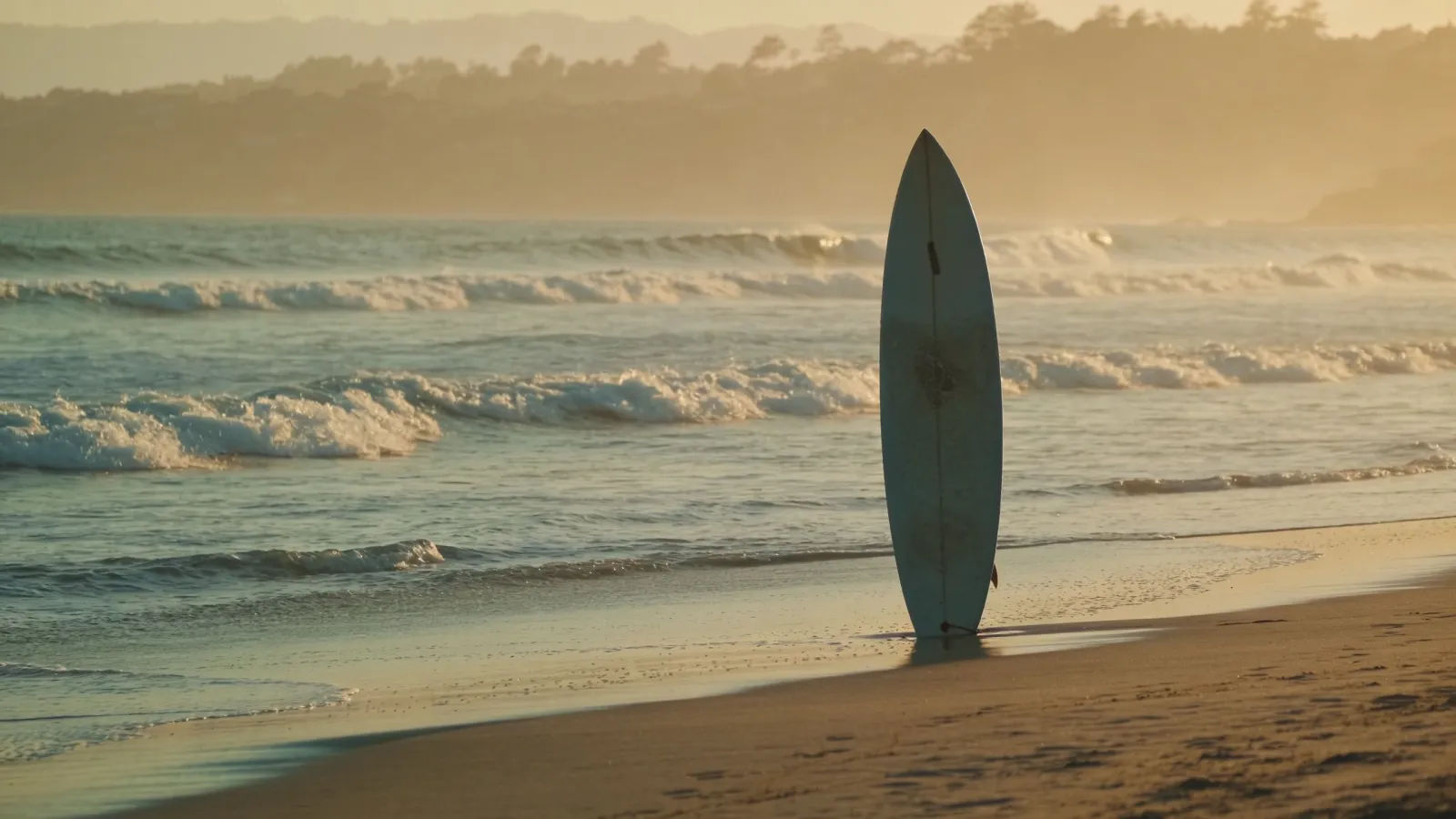 Sunlit dawn beach with a planted surfboard