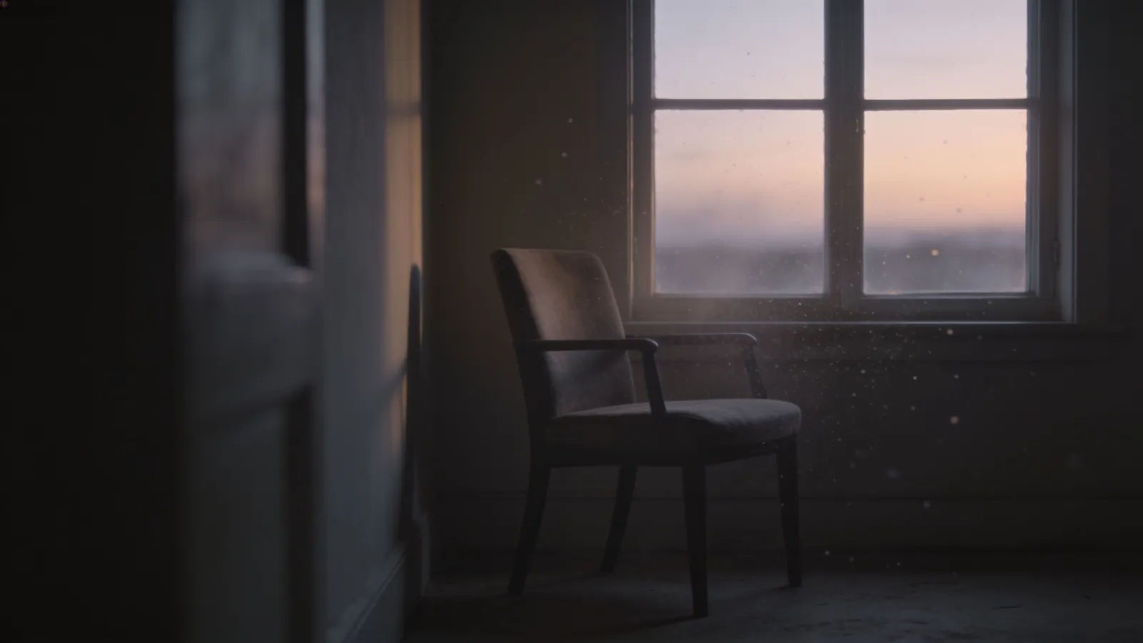 Single empty chair by a window at dusk