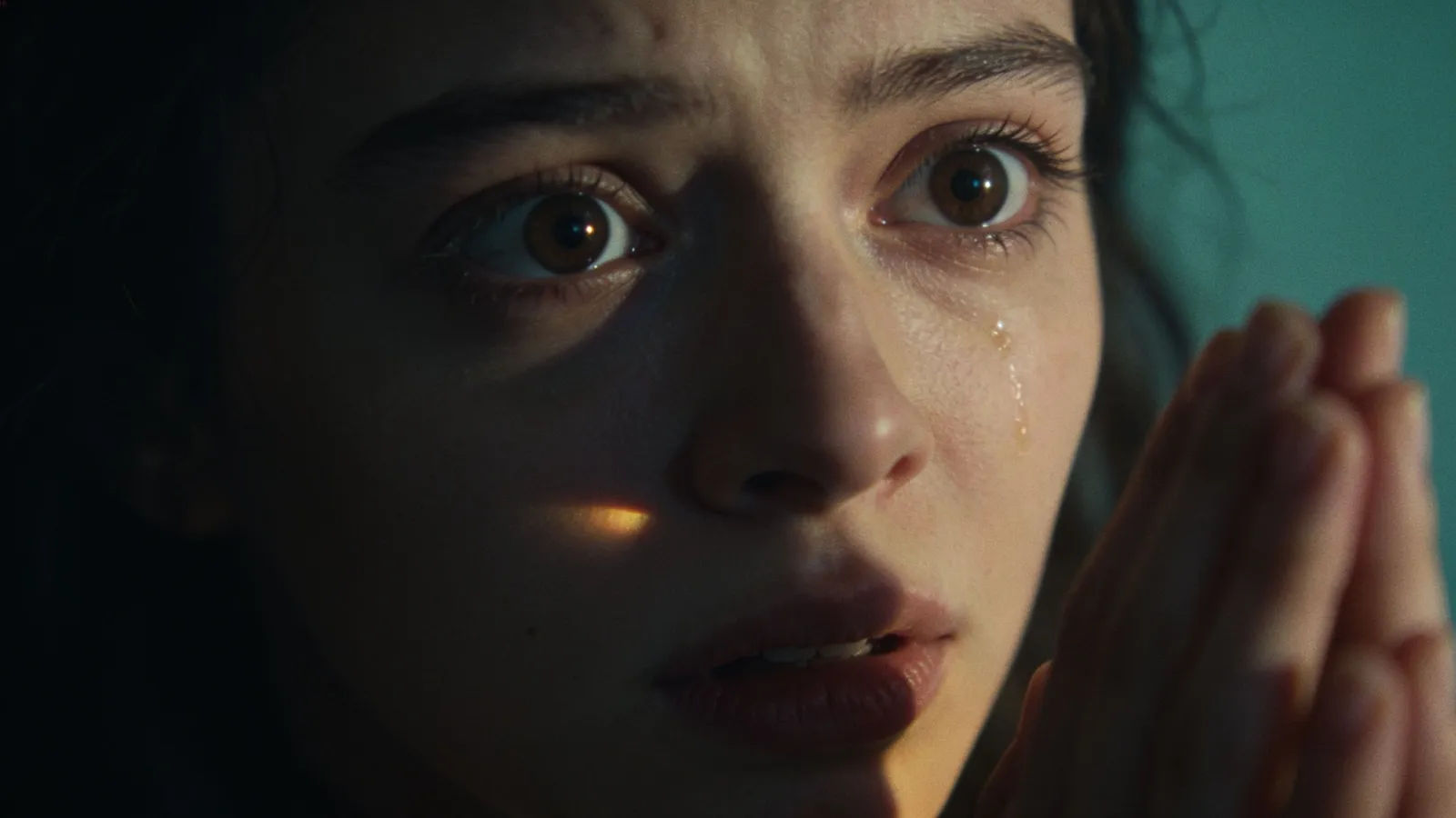 Frightened young woman in dramatic chiaroscuro cinematic portrait