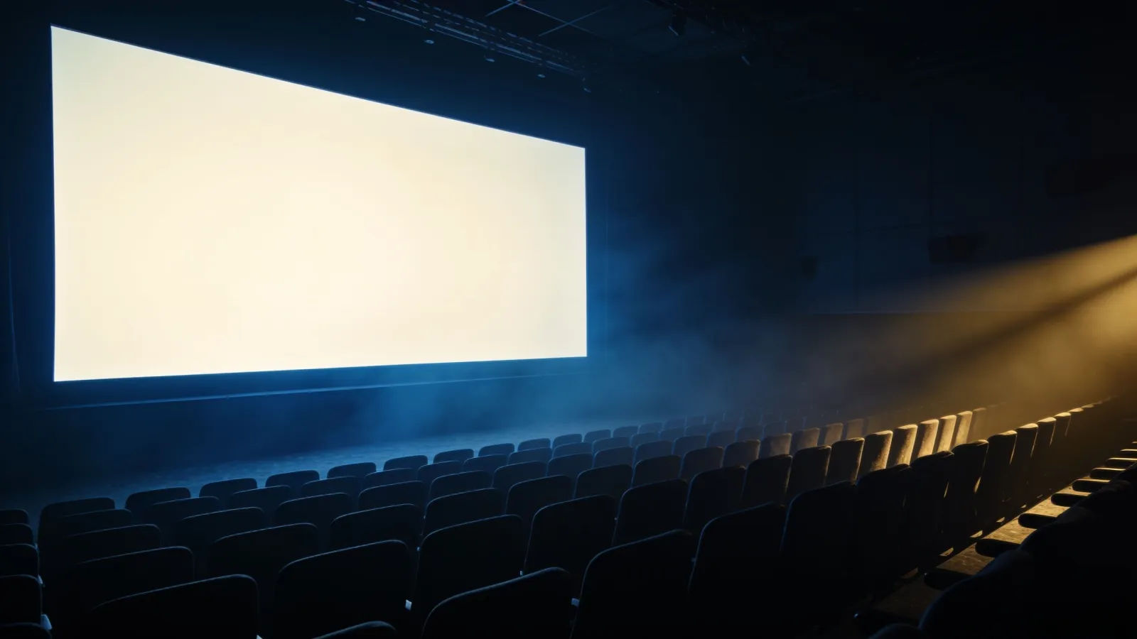 Darkened cinema with glowing screen and empty seats