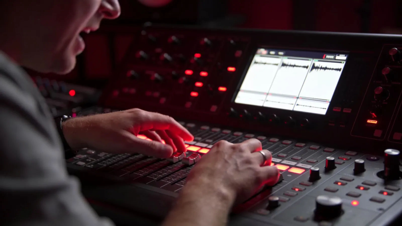 Hands at console with red audio UI