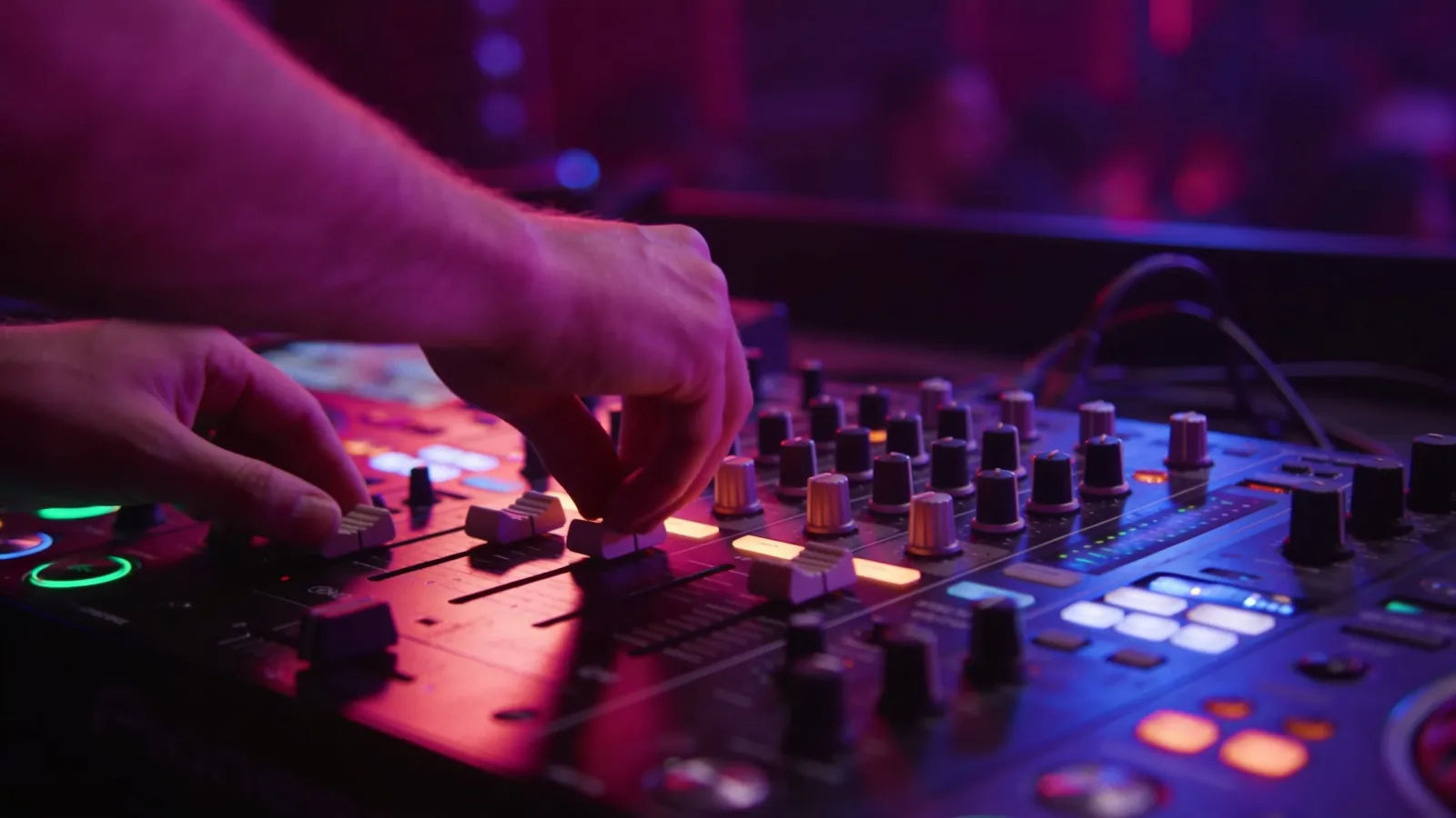 Hands on glowing DJ mixing console