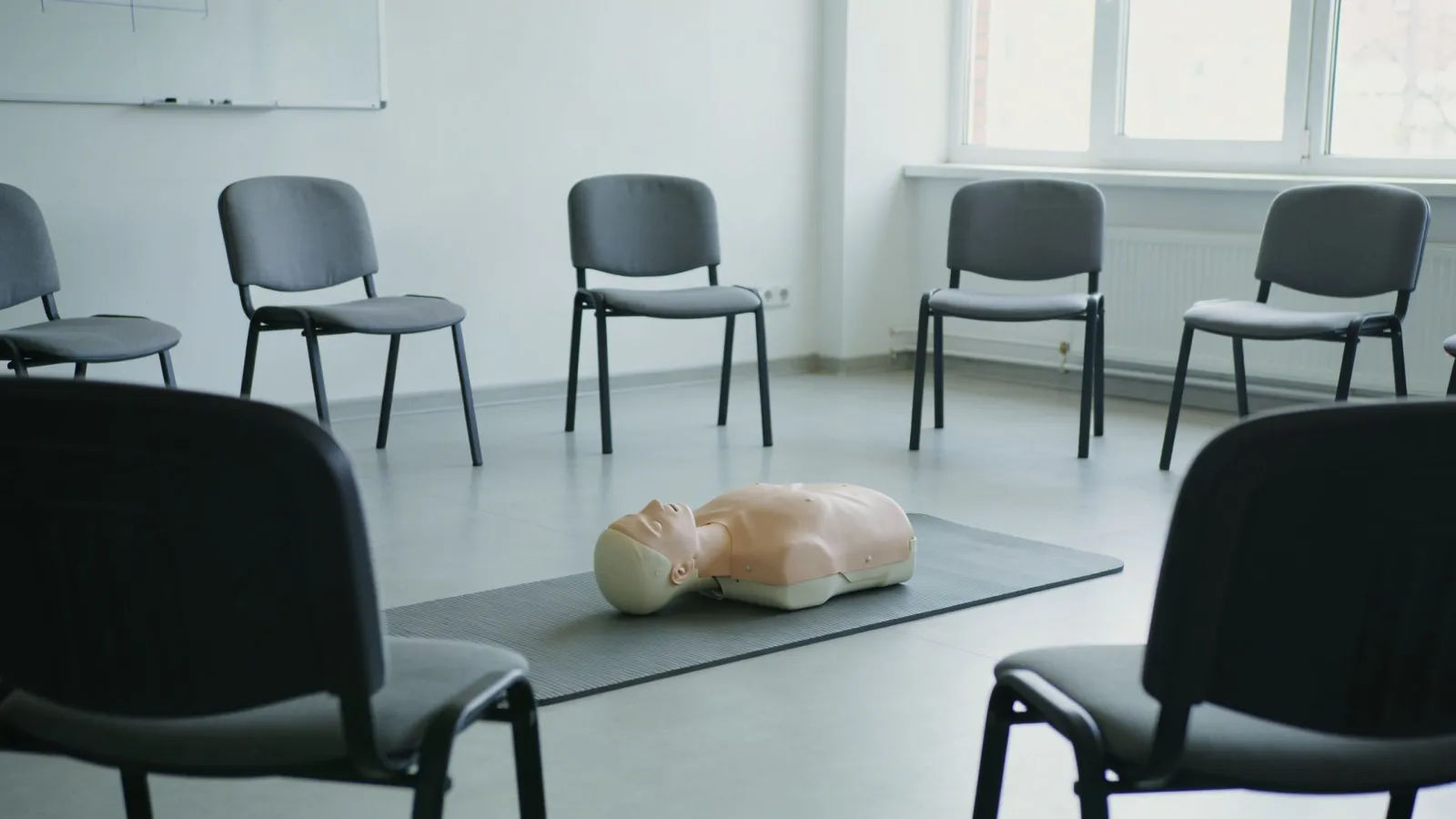 Bright training room with resuscitation mannequin and chairs