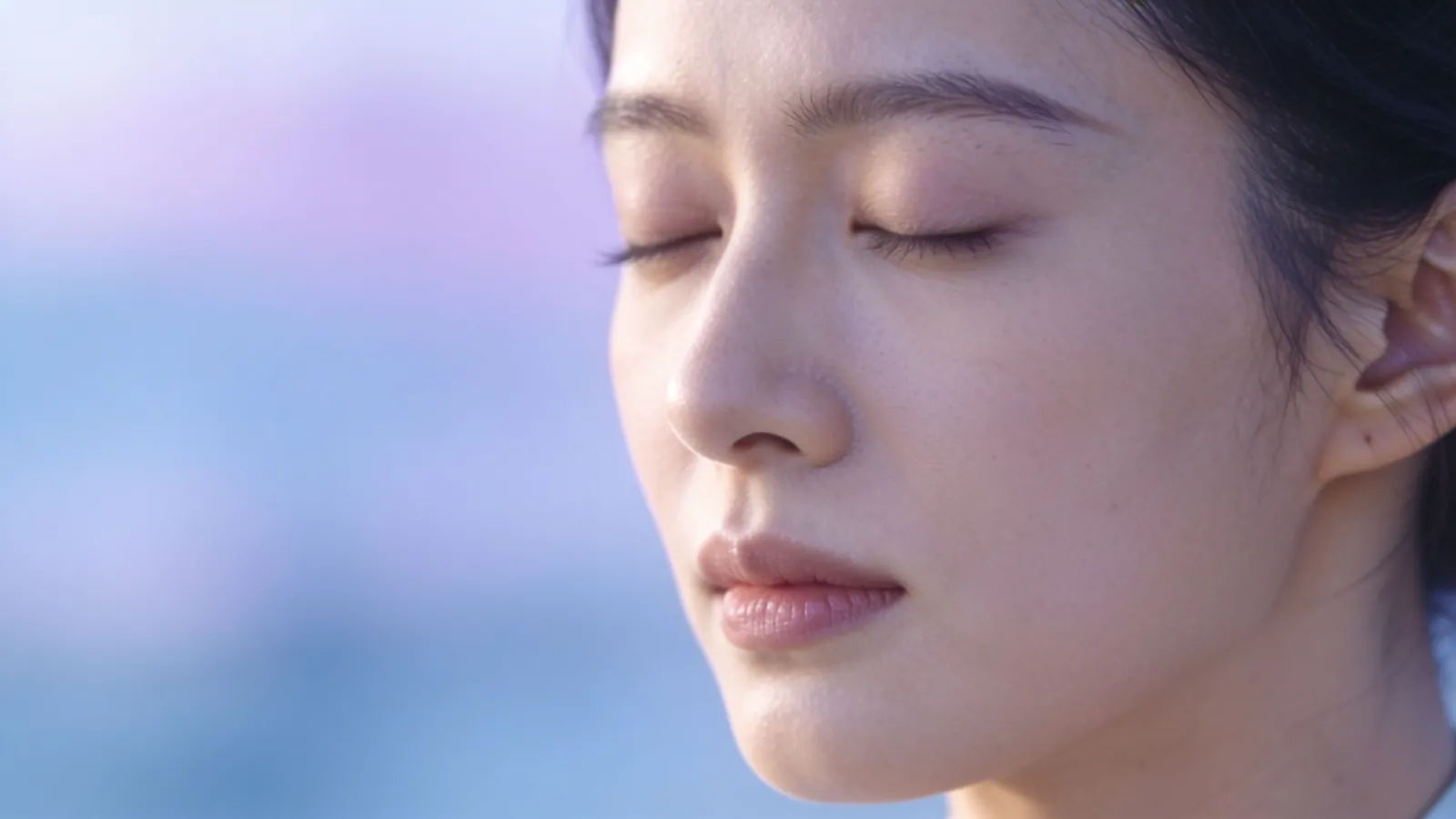 Serene woman with closed eyes in soft light