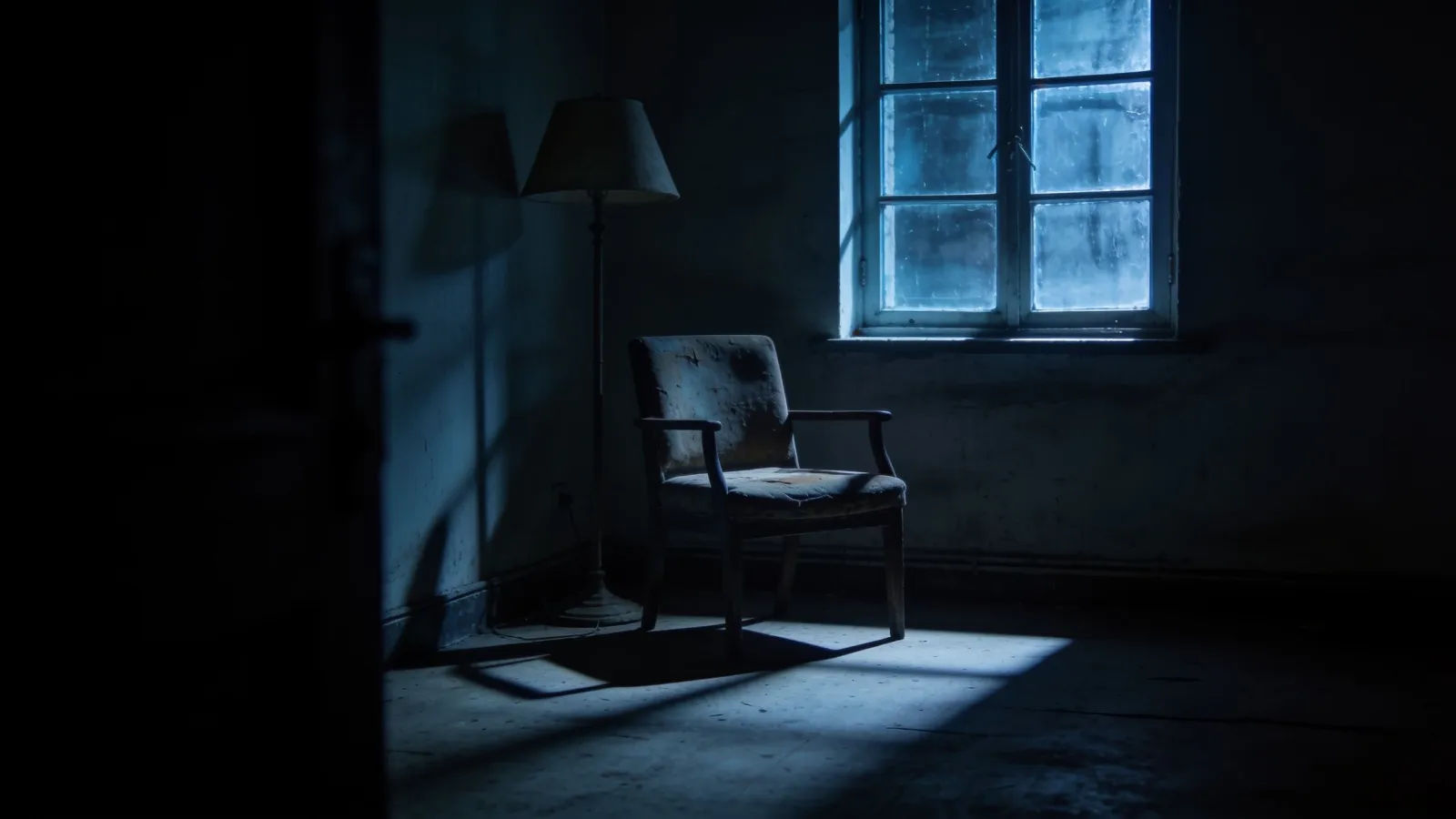 Dim late-night room with worn chair and lamp