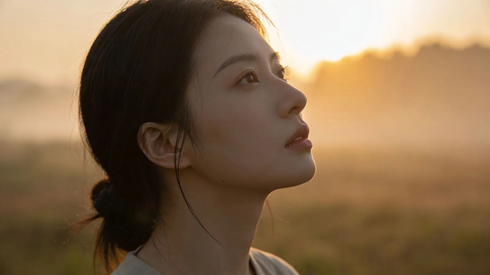 Serene person gazing toward soft dawn light
