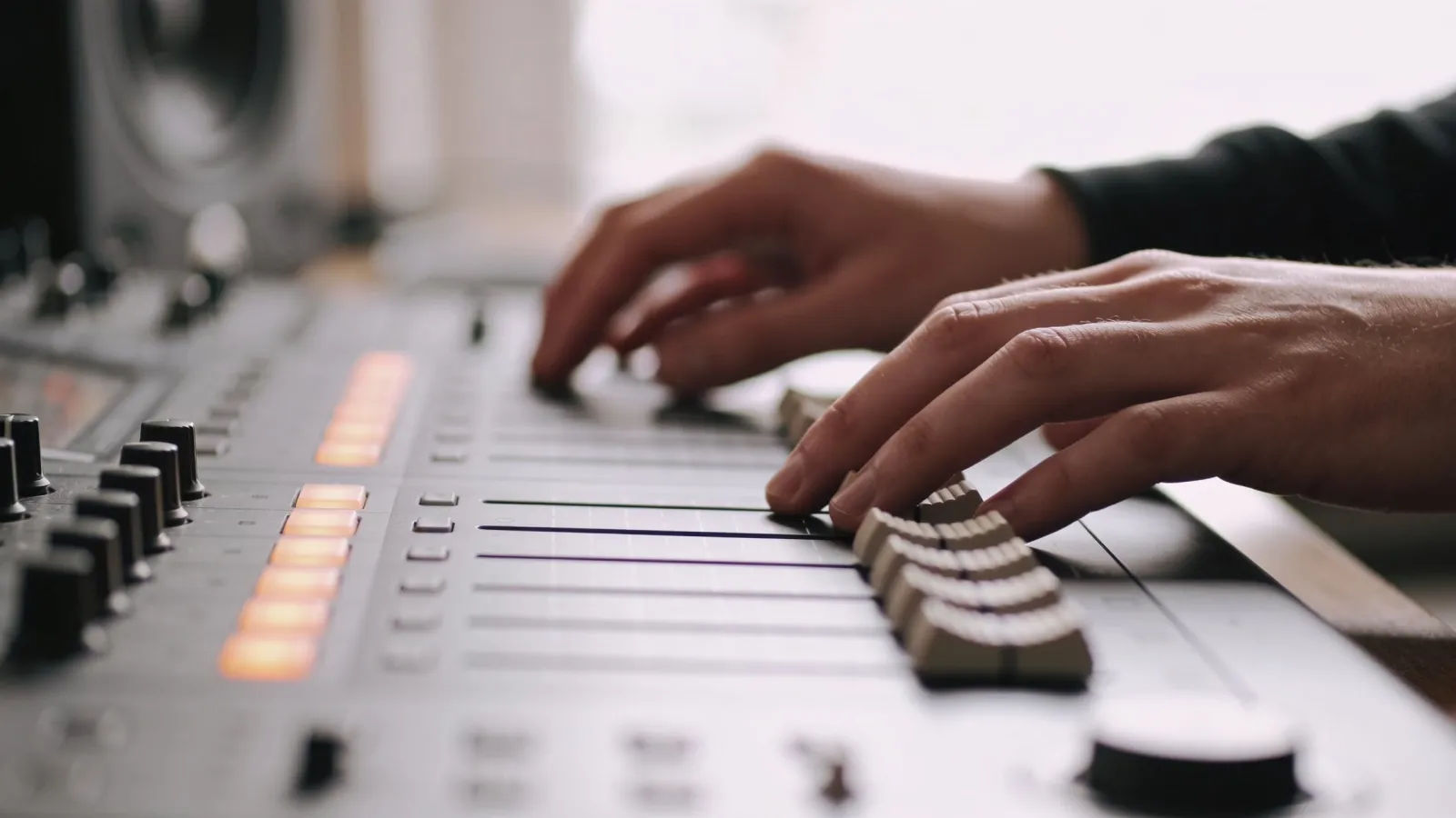 Hands at clean modern console with subtle audio panels