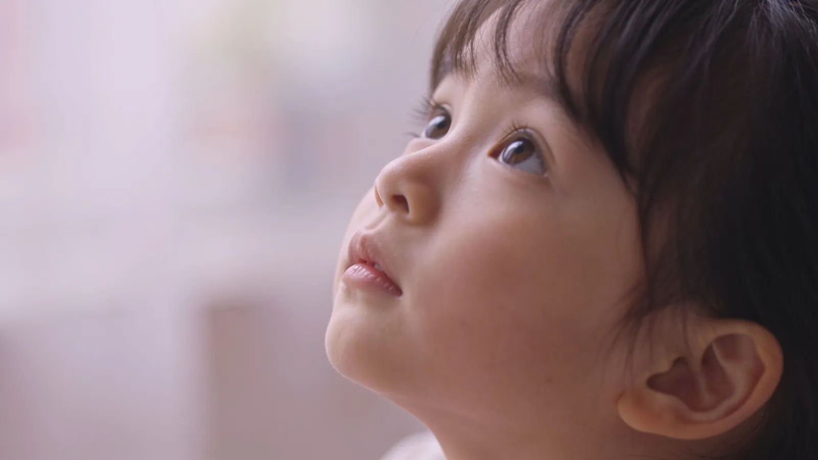 Wide-eyed young child looking up with wonder