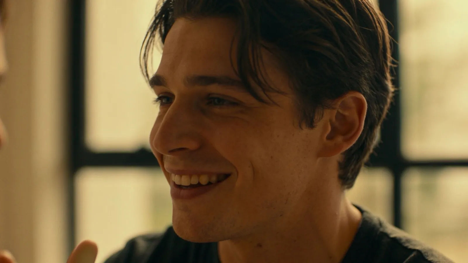 Relaxed person mid-conversation in soft window light