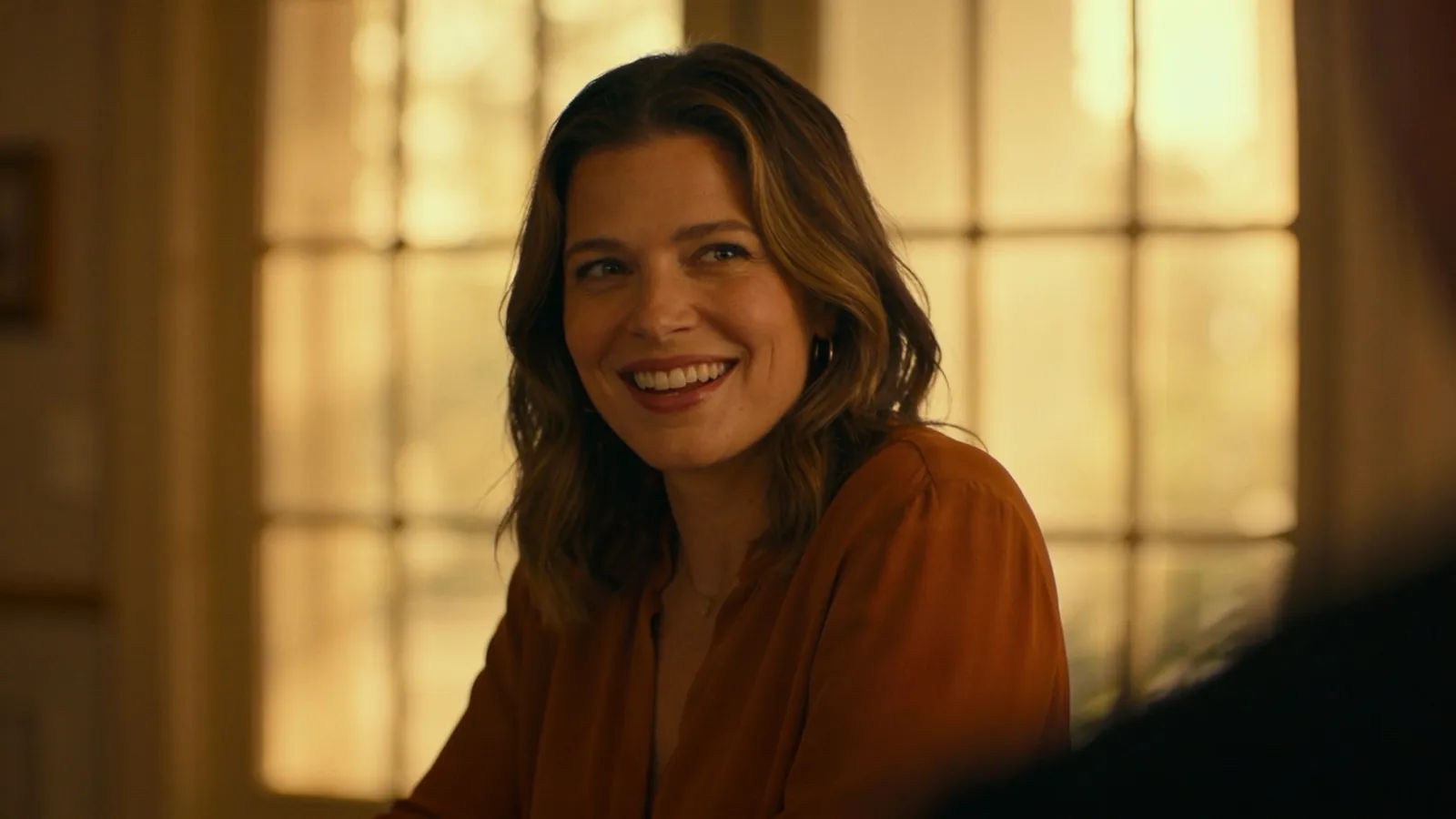 Warm friendly host smiling in soft golden light