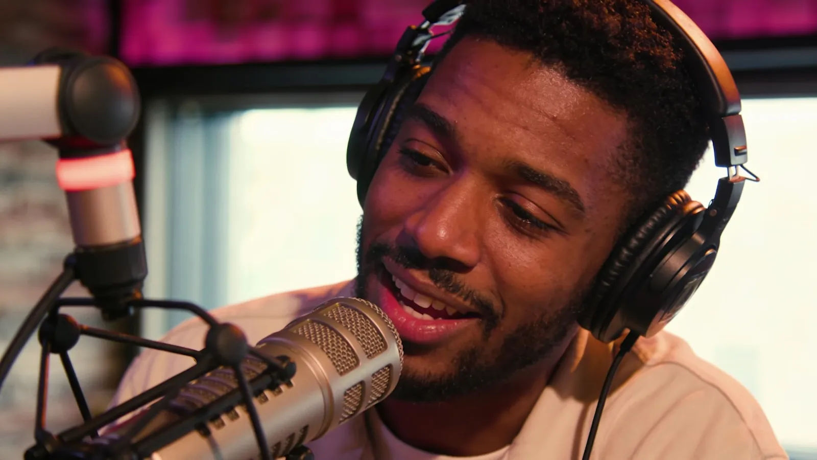 Charismatic radio host at a broadcast mic in headphones