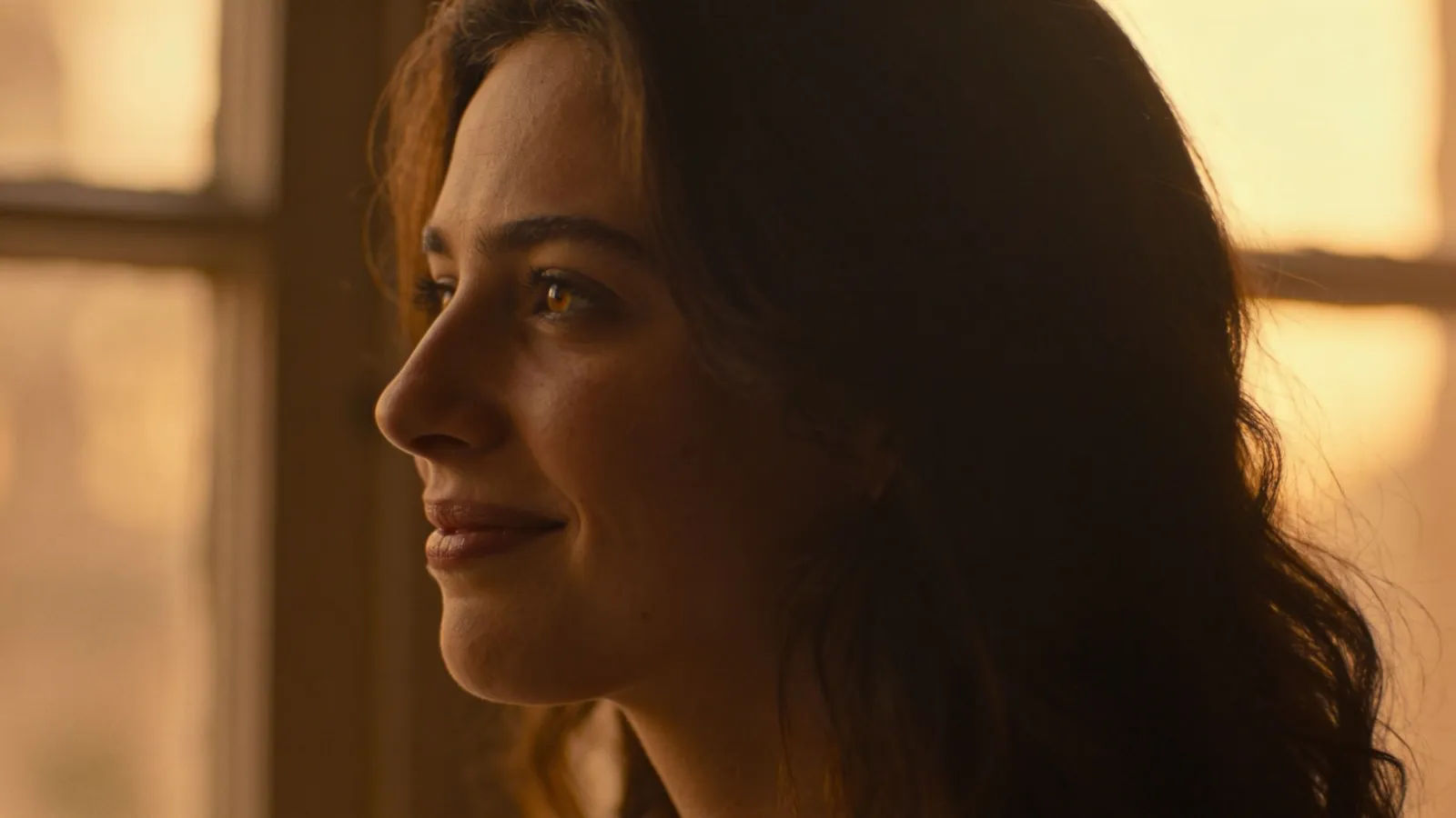 Tender storyteller with soft wistful smile in golden light