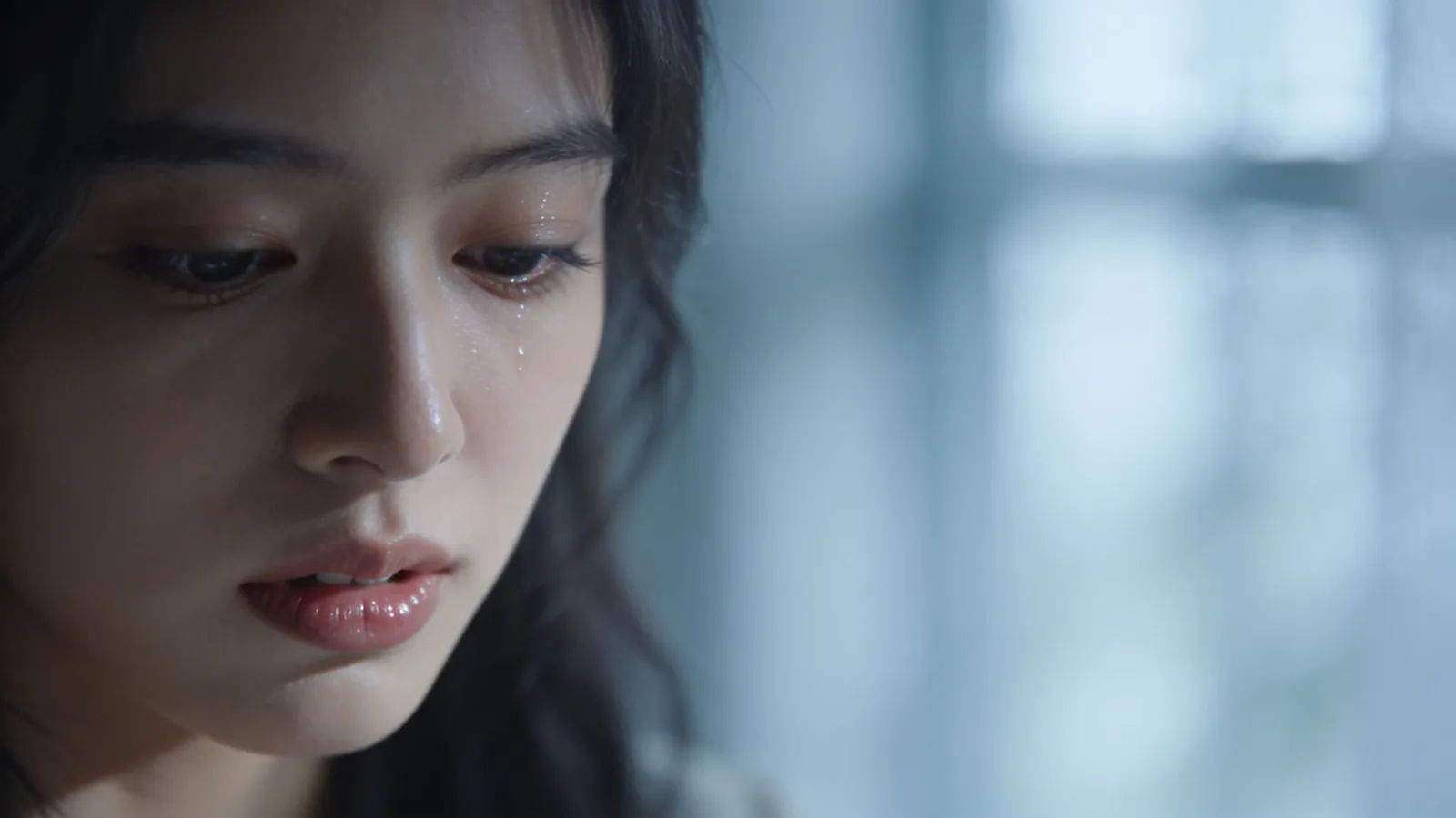 Young woman with wistful heartbroken expression, soft light