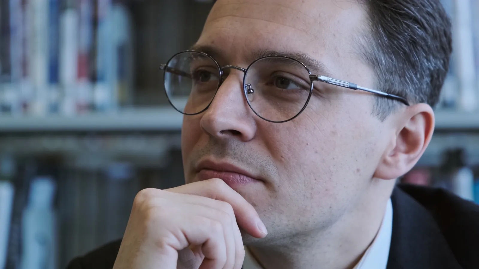 Thoughtful scholar wearing glasses, measured expression