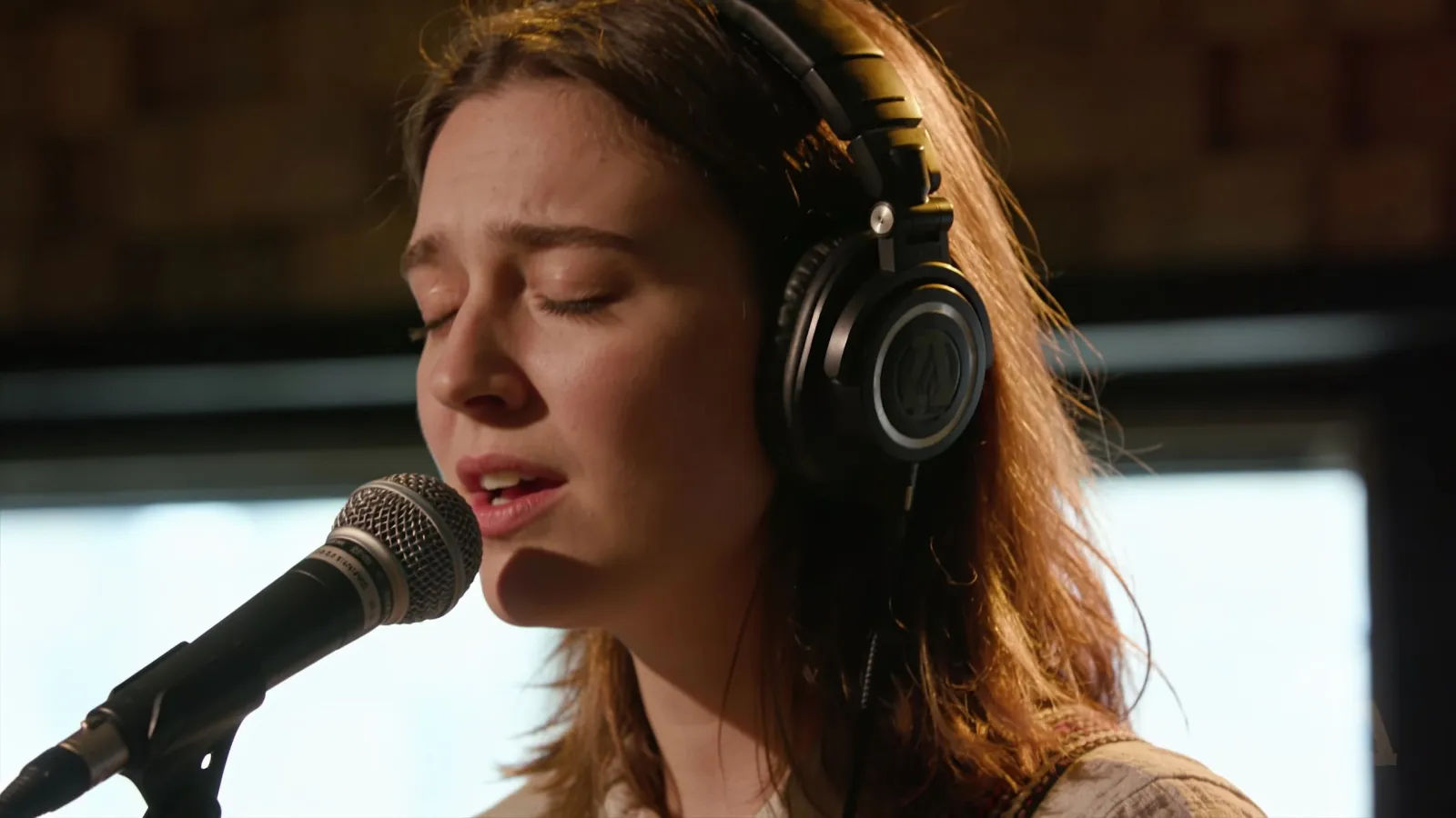 Expressive vocalist singing at a studio microphone