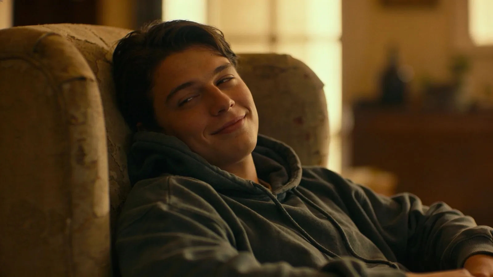 Relaxed slouched young adult with a lazy half-smile