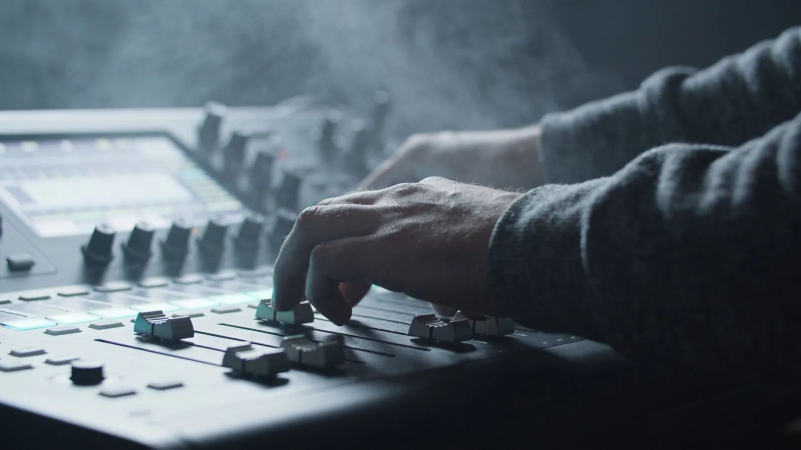 Hands on console in pale glow