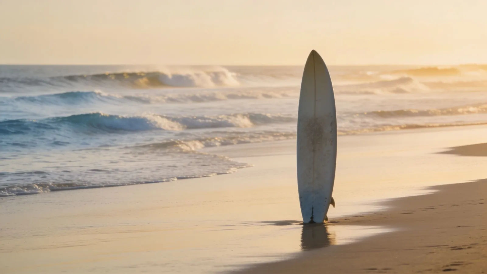 Empty surf break at golden hour with lone board