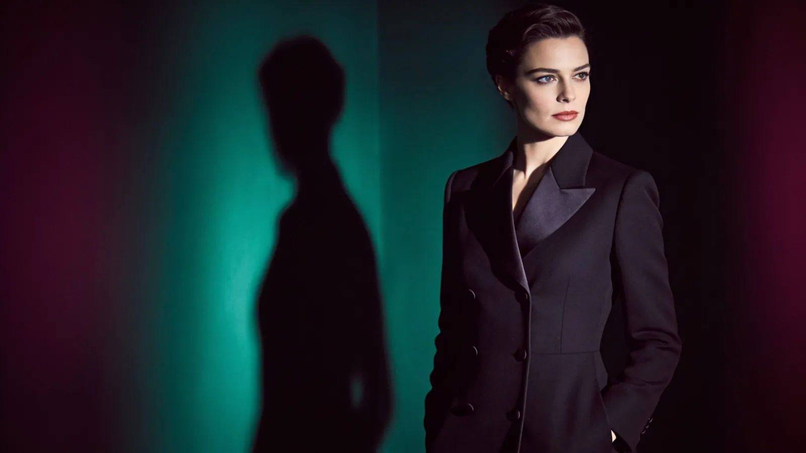 Elegant poised fully-clothed figure in noir shadow