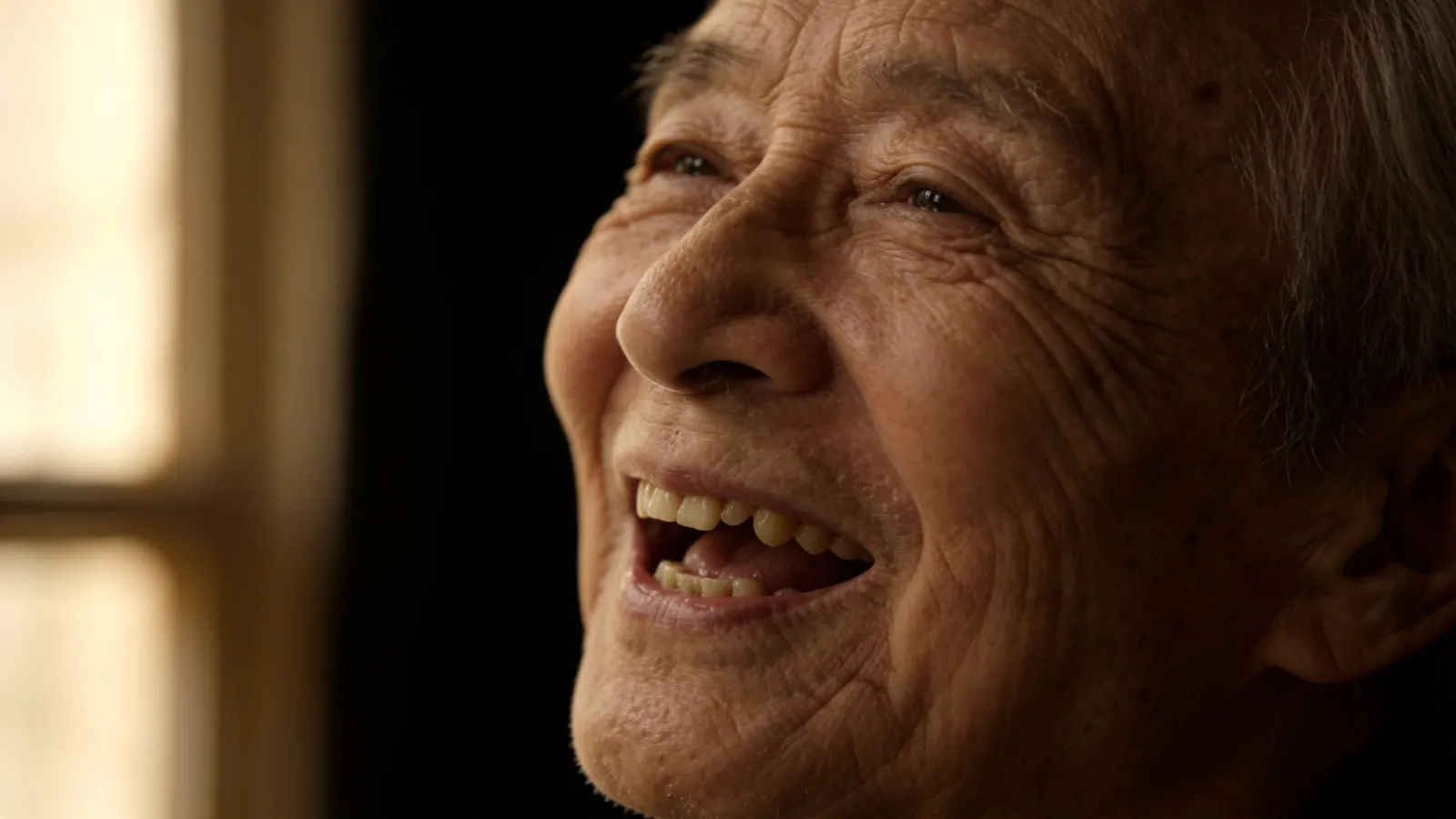 Elderly person laughing with gummy toothless smile