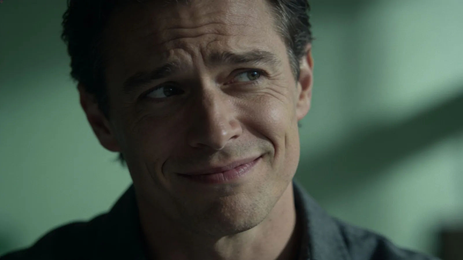 Uneasy adult with a tense wincing half-smile