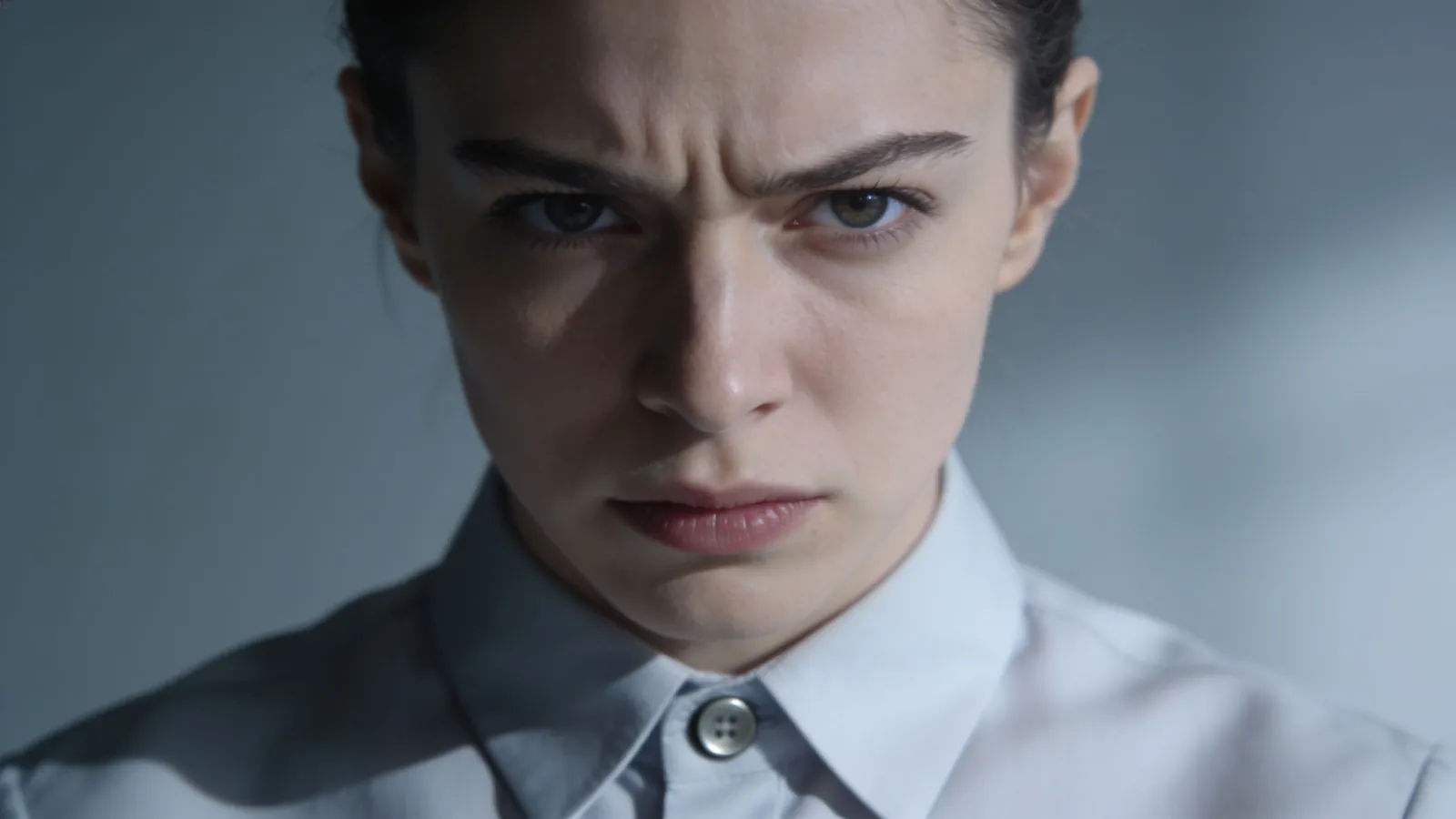 Prim tense character with pinched expression in cold light