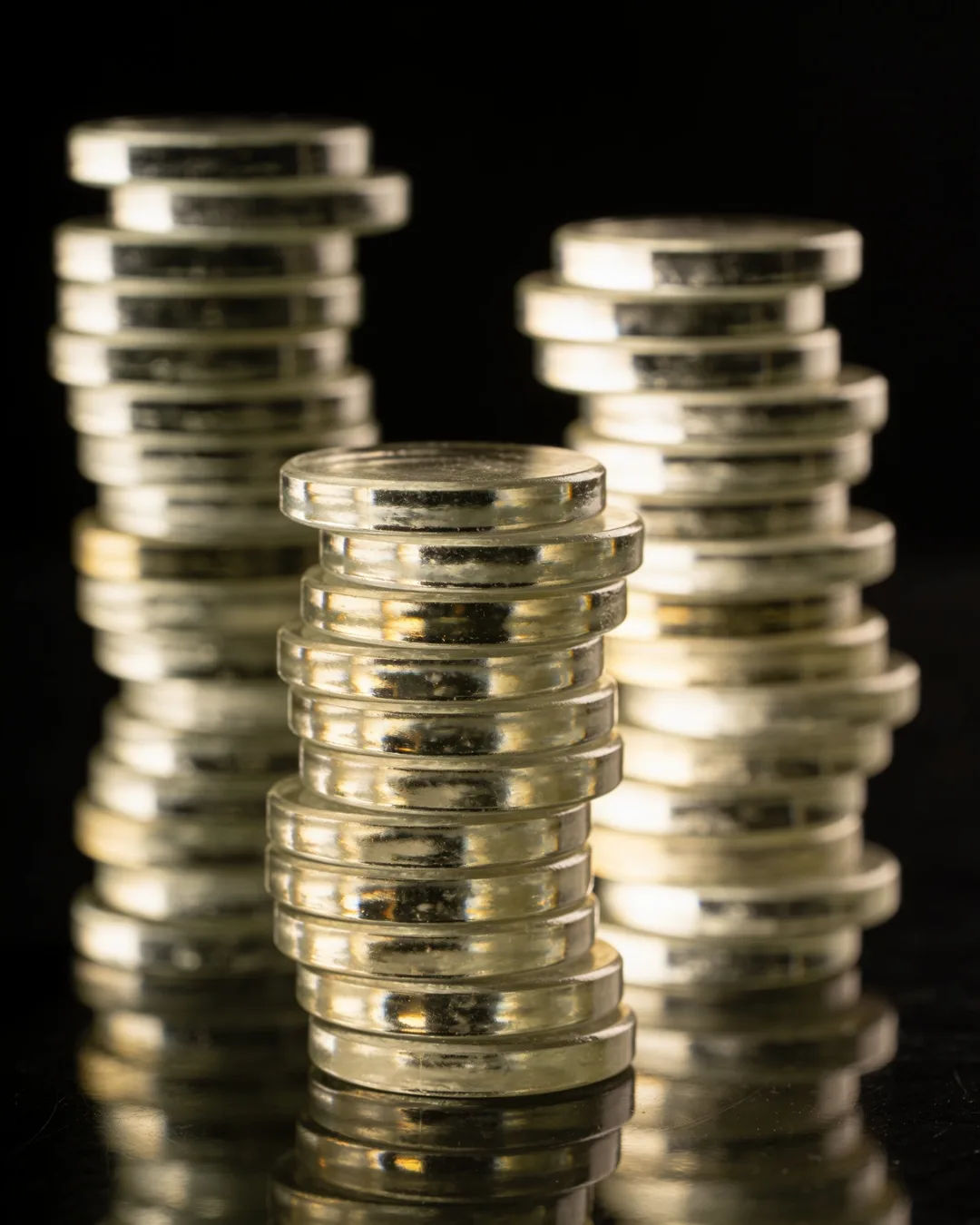 Stacks of glass tokens rising on a black ground