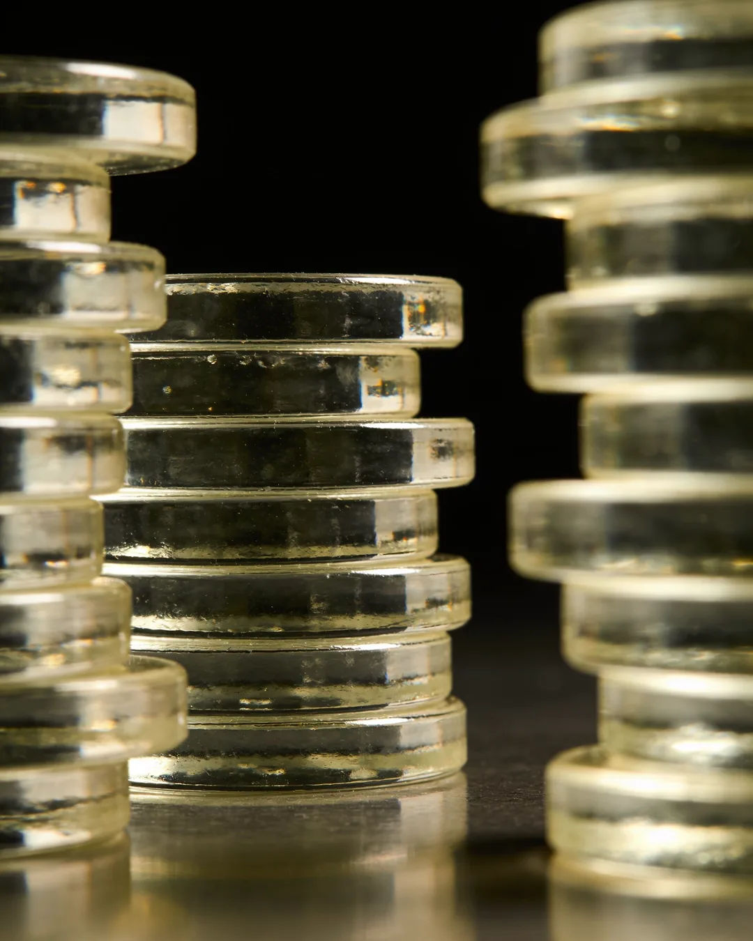 Stacks of glass tokens rising on a black ground