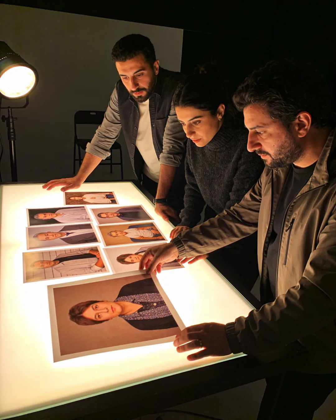 An Albanian production team reviewing printed frames on a lit table