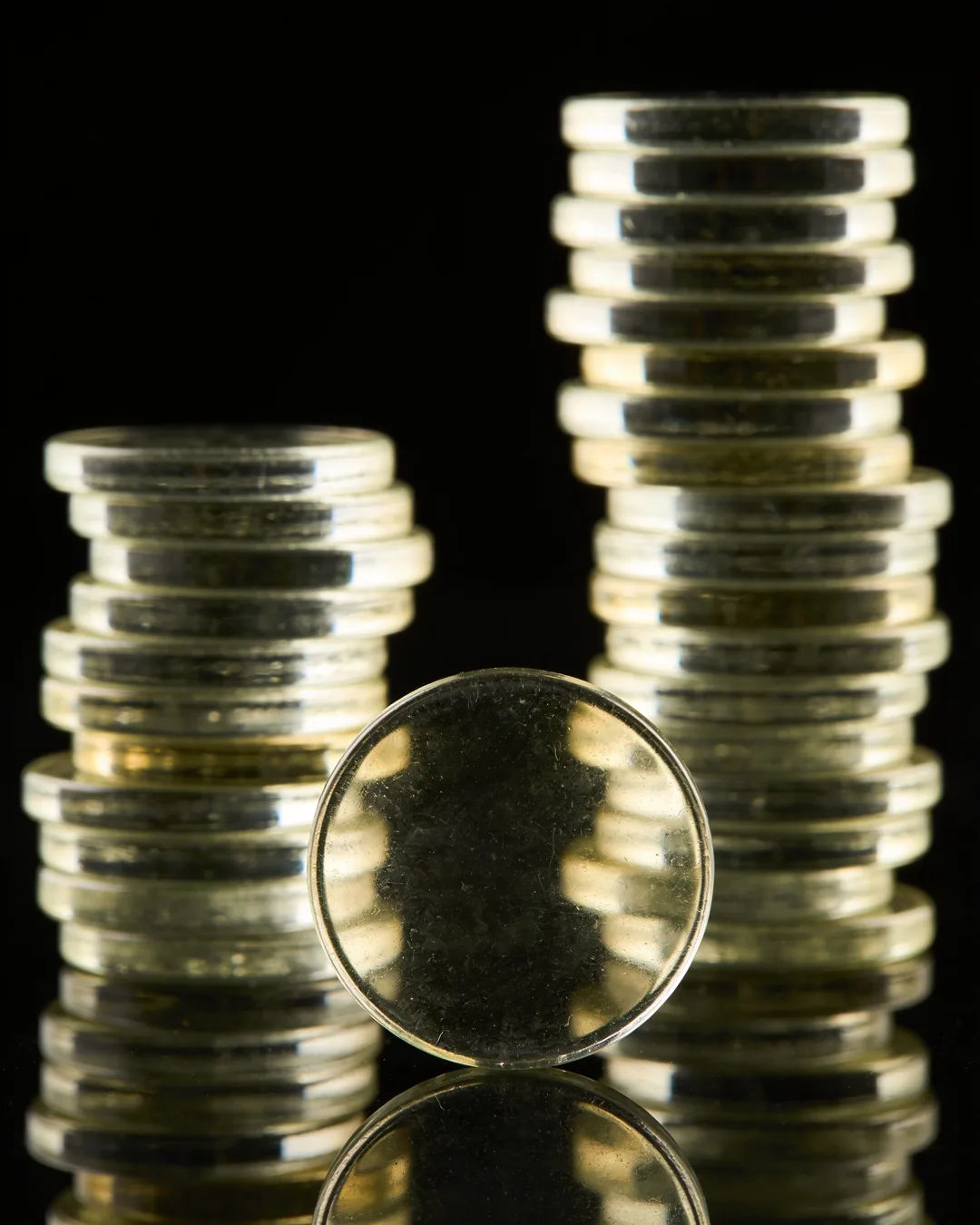 Stacks of glass tokens rising on a black ground