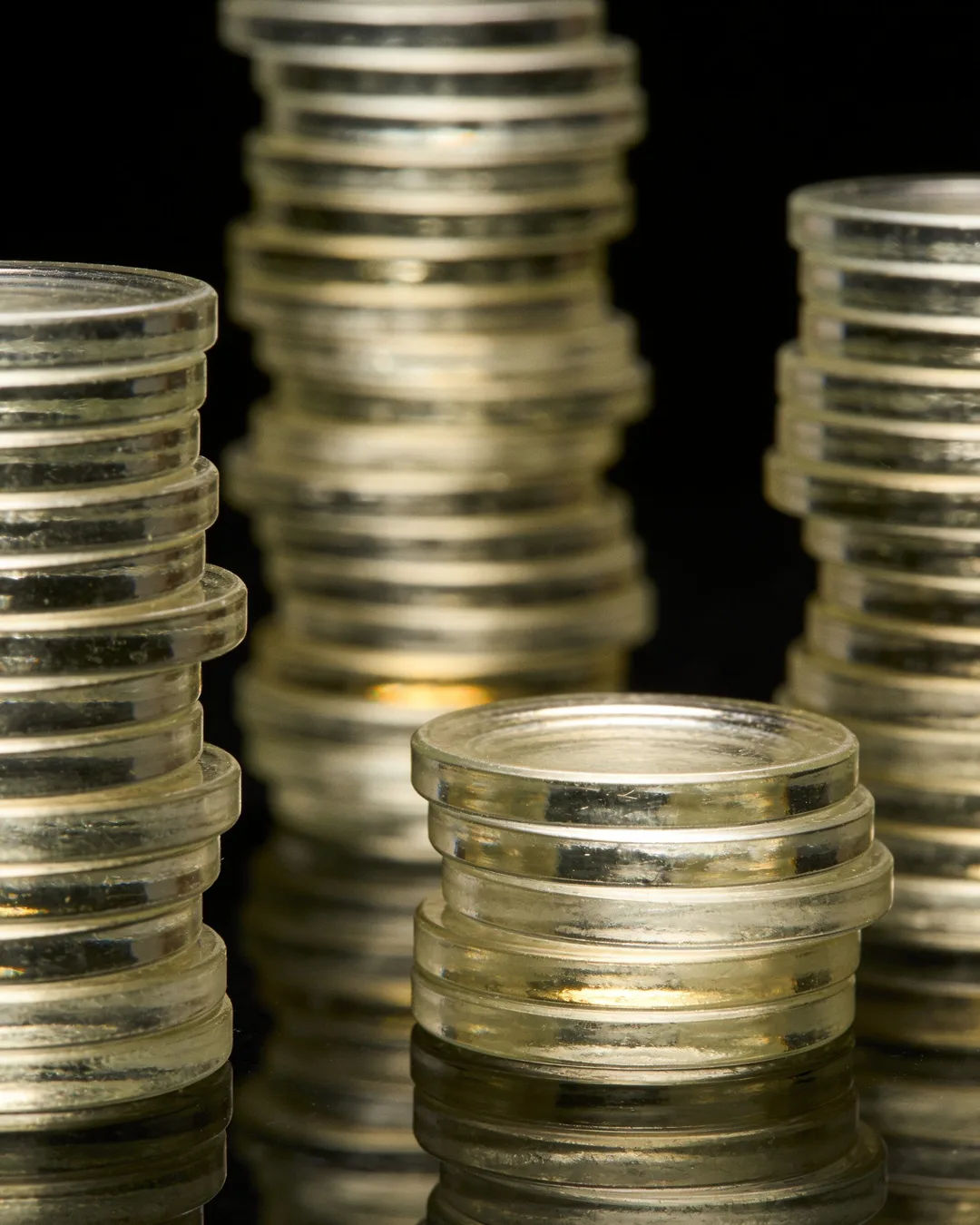 Stacks of glass tokens rising on a black ground