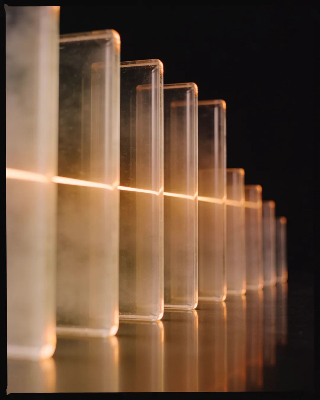 Glass columns of different heights with a glowing limit line
