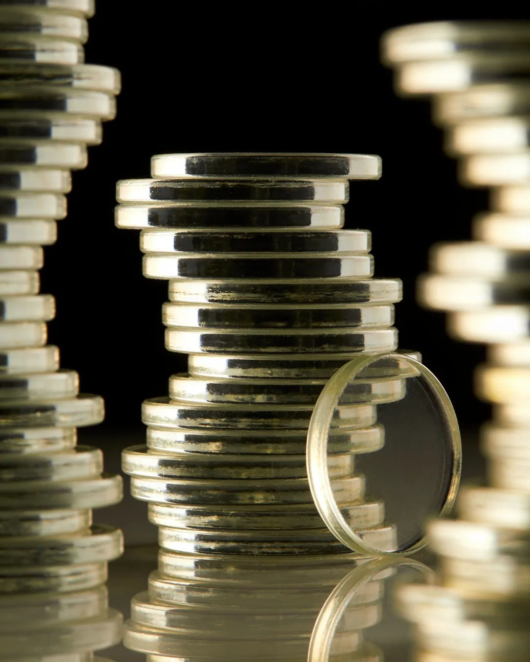 Stacks of glass tokens rising on a black ground