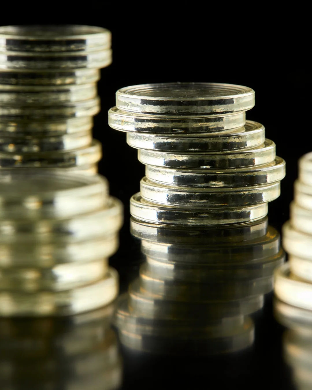 Stacks of glass tokens rising on a black ground