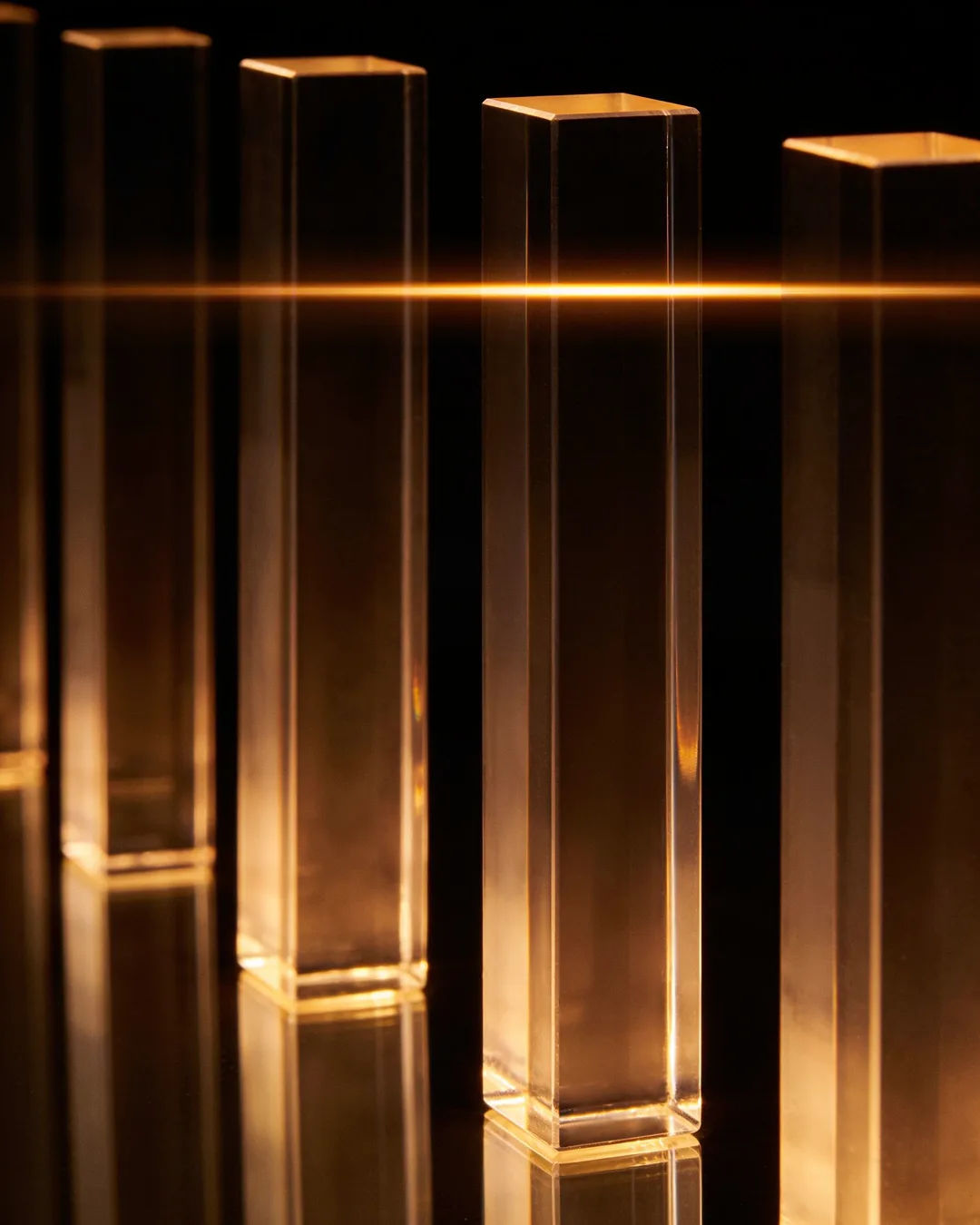 Glass columns of different heights with a glowing limit line