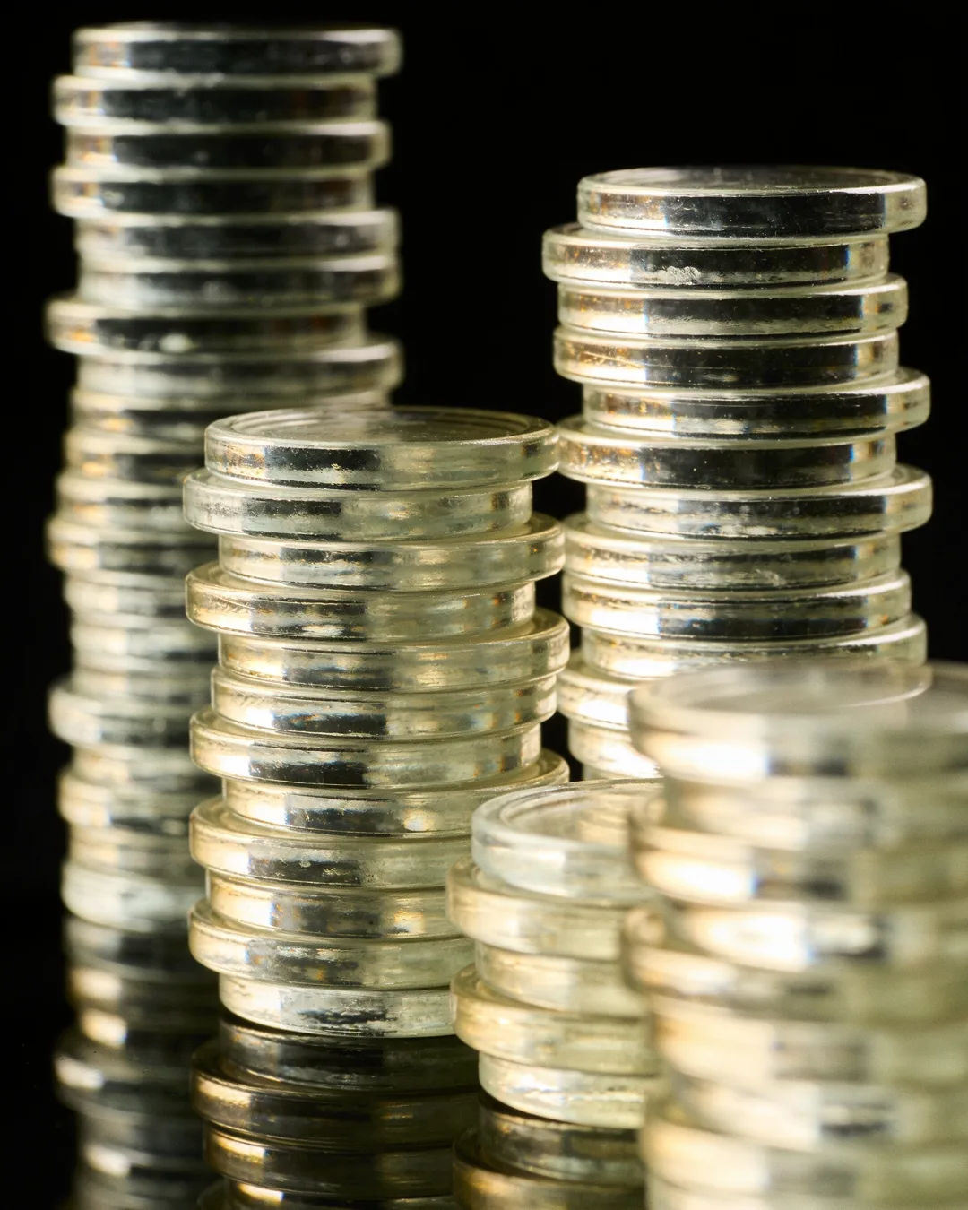 Stacks of glass tokens rising on a black ground